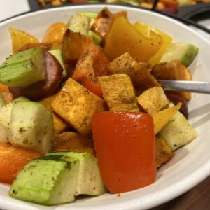 Close up photo of baked zucchinis, andouille sausage, and bell peppers