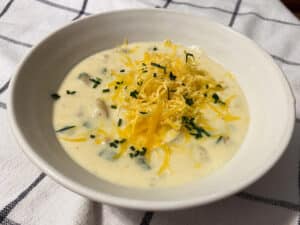 creamy baked potato soup with shredded cheddar cheese and chives