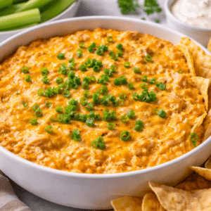 buffalo chicken dip in a serving bowl with tortilla chips on the side
