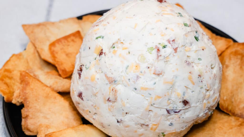 cheddar bacon ranch cheeseball on a plate with pita chips