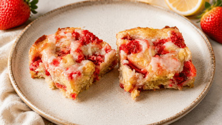 strawberry lemon shortcake two slices sitting on a plate with strawberries and a sliced lemon in the background
