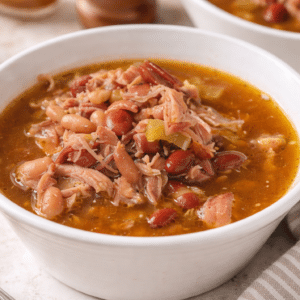 hearty ham and bean soup in a bowl with spoon next to the bowl
