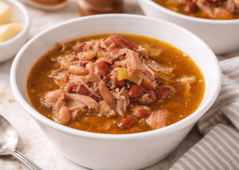 hearty ham and bean soup in a bowl with spoon next to the bowl