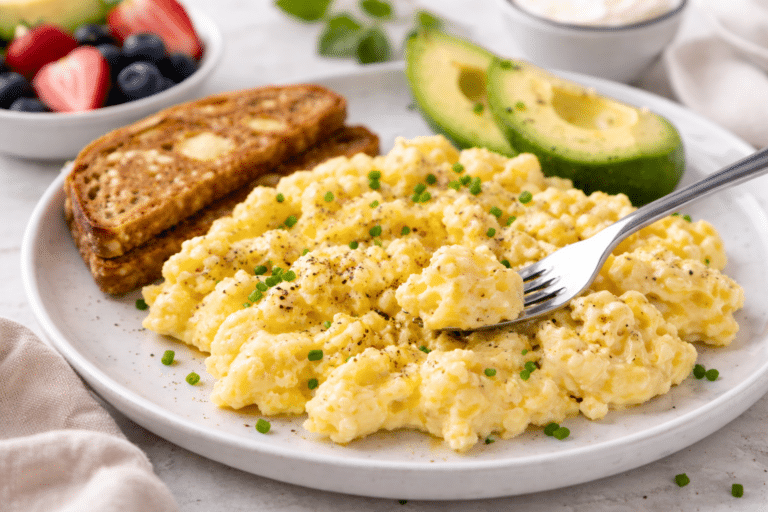 high protein scrambled eggs with cottage cheese sitting on a plate with avocado and toast